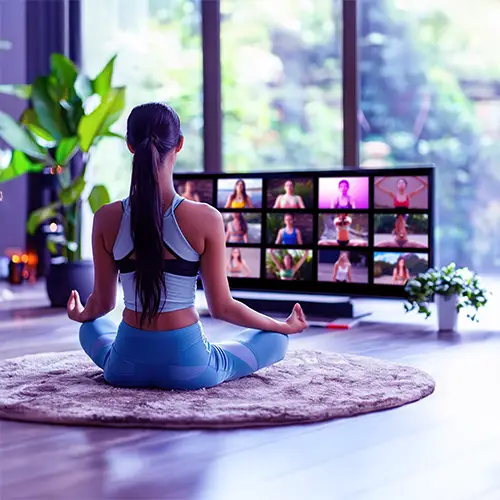 Woman meditating in front of an online class screen